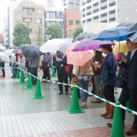 雨の中、開店を待つ人の列