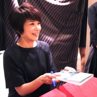 サインした本を手渡す黒田知永子