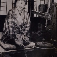 菊池洋守作の紬の着物に田島隆夫作の羽織をはおる白洲正子。自宅にて。