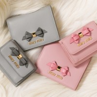リボン付き レザーグッズ 「二つ折り財布」（3万9,000円）左上：グレー、右下：ピンク 「ミニ財布」（4万2,000円）左下：グレー、右上：ピンク