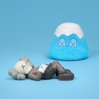 左：「KAWS:HOLIDAY JAPAN 9.5インチ ビニールフィギュア」ブラウン（約24cm 各2万1,700円）、右：「KAWS:HOLIDAY JAPAN 富士山 8インチ ぬいぐるみ（シリアル番号証明書付き）」ブルー（約21cm 1万9,600円）