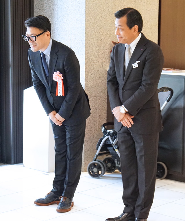 伊勢丹新宿店の正面玄関で開店の挨拶をする丸山敬太（左）と伊勢丹新宿本店長の鷹野正明（右）