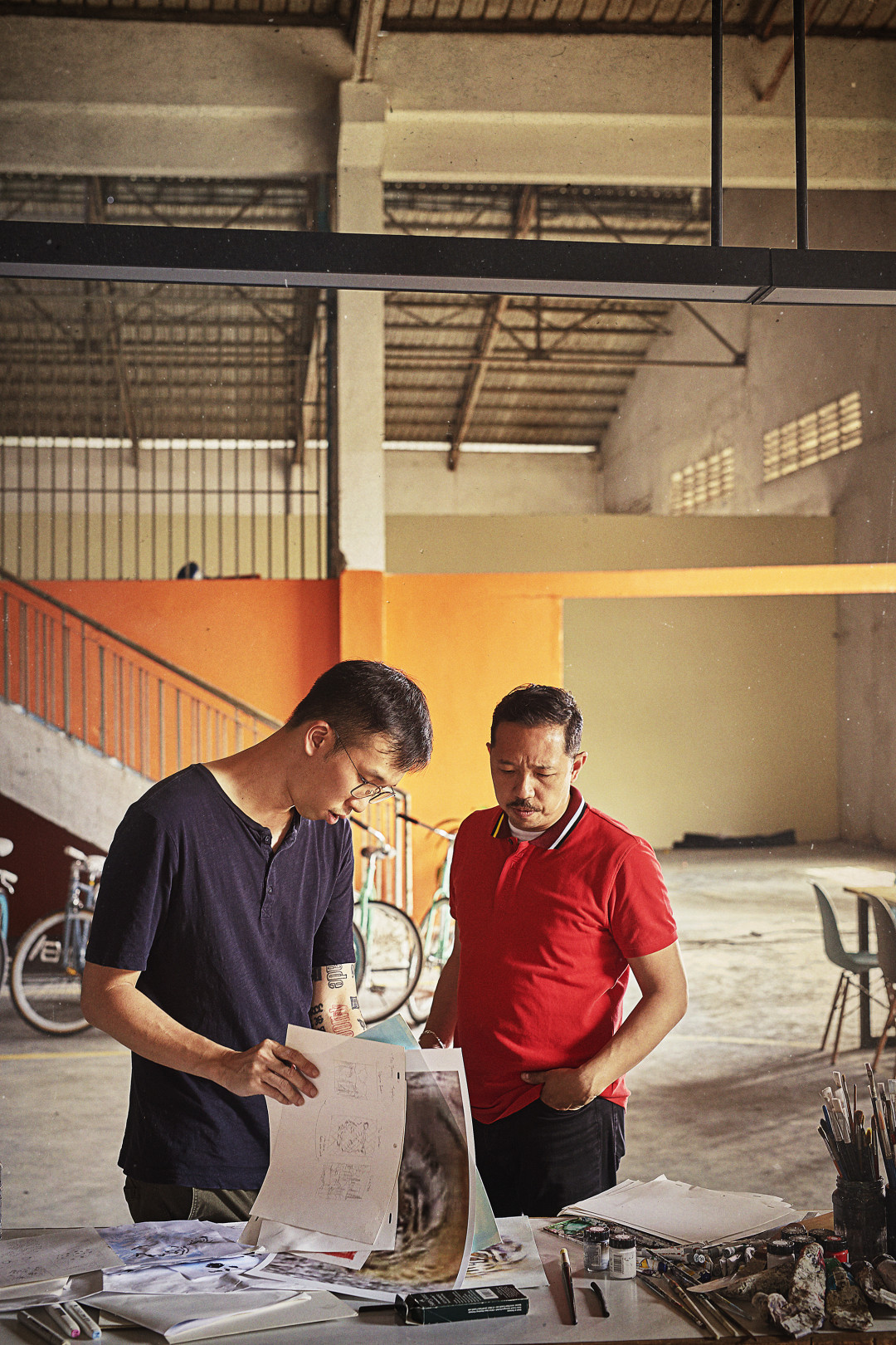 Artist Sean Lean (MY) and KENZO's Humberto Leon reviewing notes and sketches in Cambodia