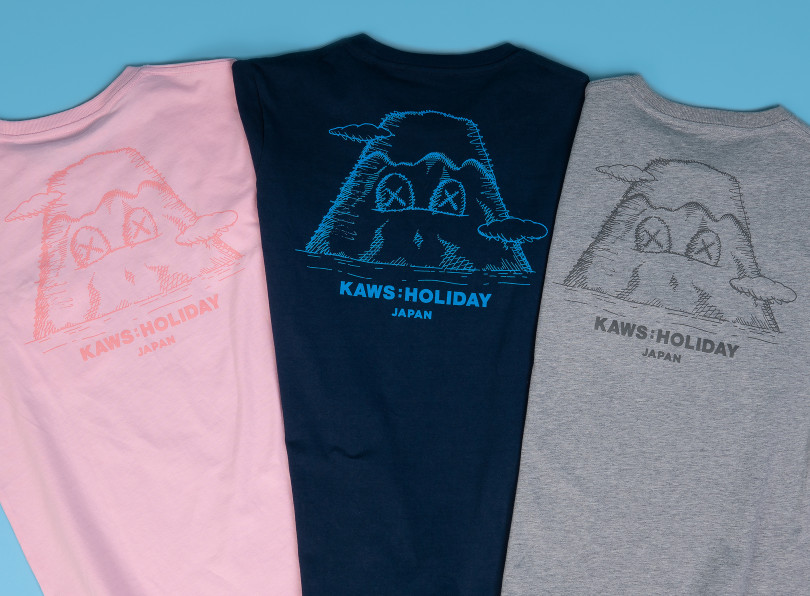 「KAWS:HOLIDAY JAPAN Tシャツ」ポケット：ピンク／ネービー／グレー（M＆L 各5,500円）
